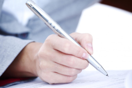 close up of person signing document with pen: Lawtery X Wills and Estate Planning Blog