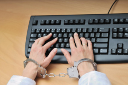 handcuffed hands typing on keyboard: LawteryX Criminal Law Blog