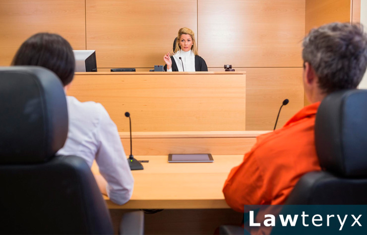 lawyer and client sitting before judge in courtroom