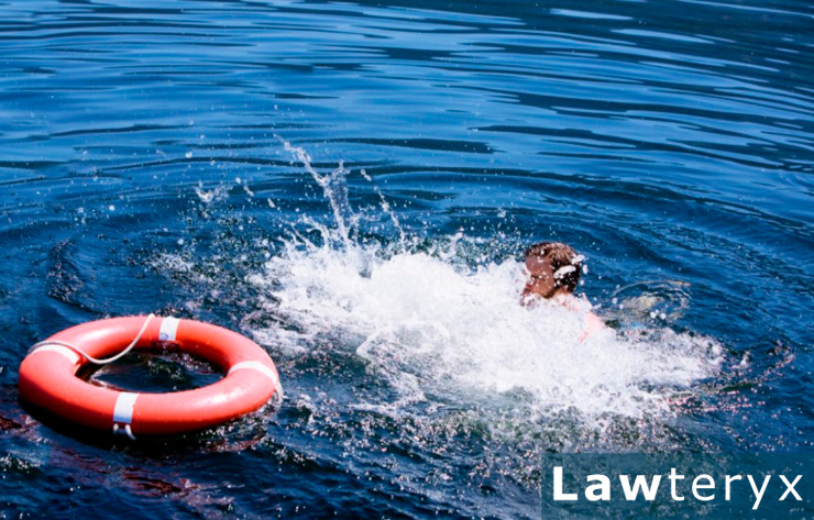 A man splashing in water near a life buoy
