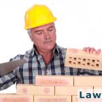 older construction worker laying bricks